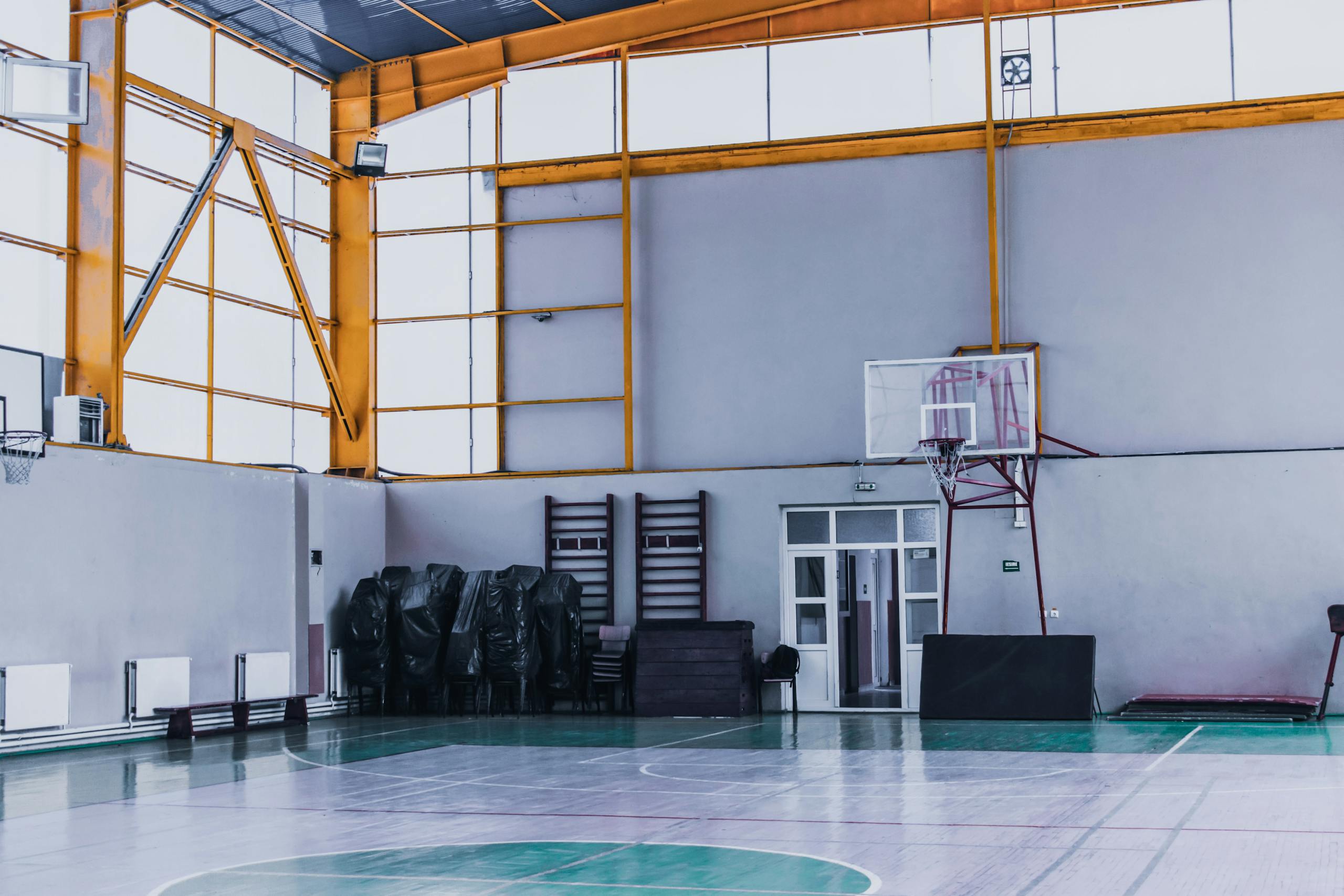 Spacious indoor basketball court featuring modern architecture, perfect for fitness and sports activities.
